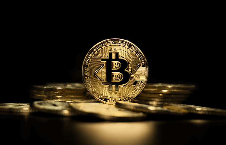 Goldene Bitcoins vor schwarzem Hintergrund.