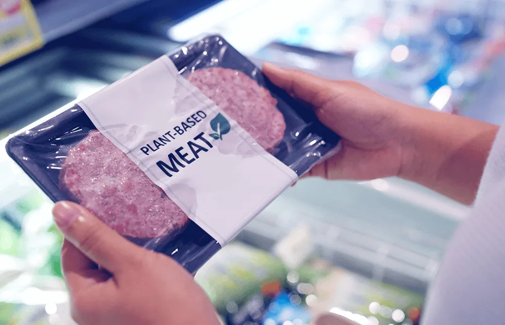 Obrázek rukou držících hamburgery z veganského masa Obrázek rukou držících hamburgery z veganského masa